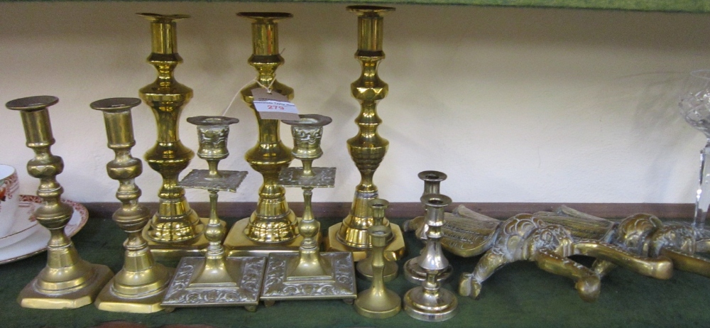 A pair of brass Beetle Boot Jacks and 11 various brass Candlesticks