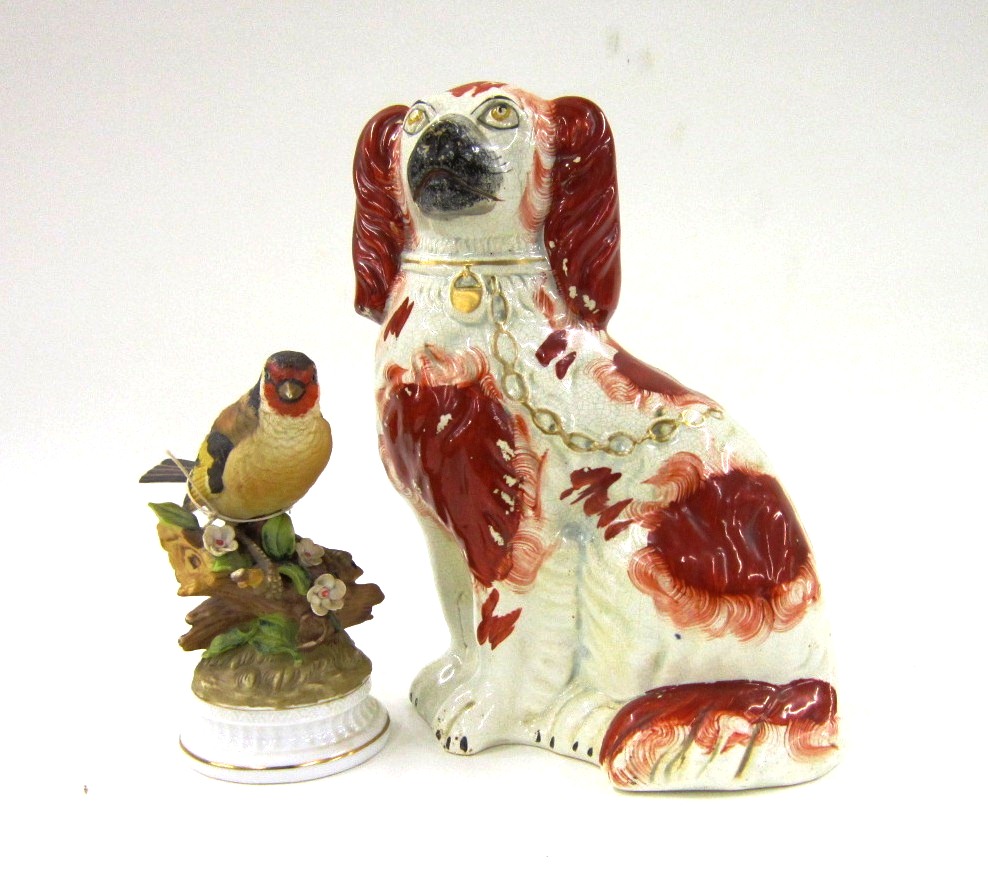 A Staffordshire Pottery Model of a seated Spaniel; and a porcelain Model of a Garden Bird, on