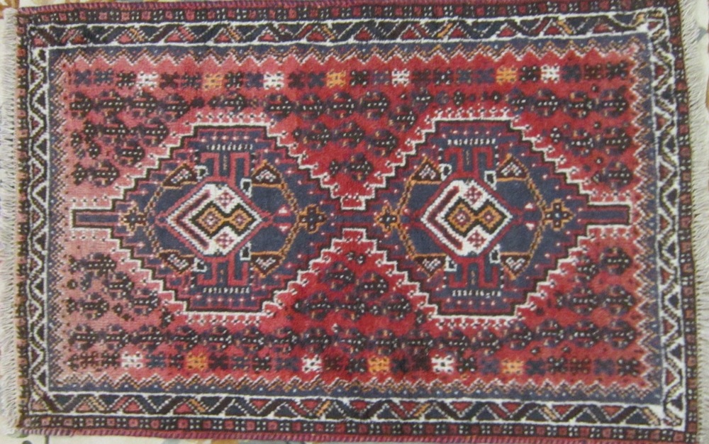 A small Persian Hamadan type Rug on a red ground, 120 x 77 cms (faded at one end)