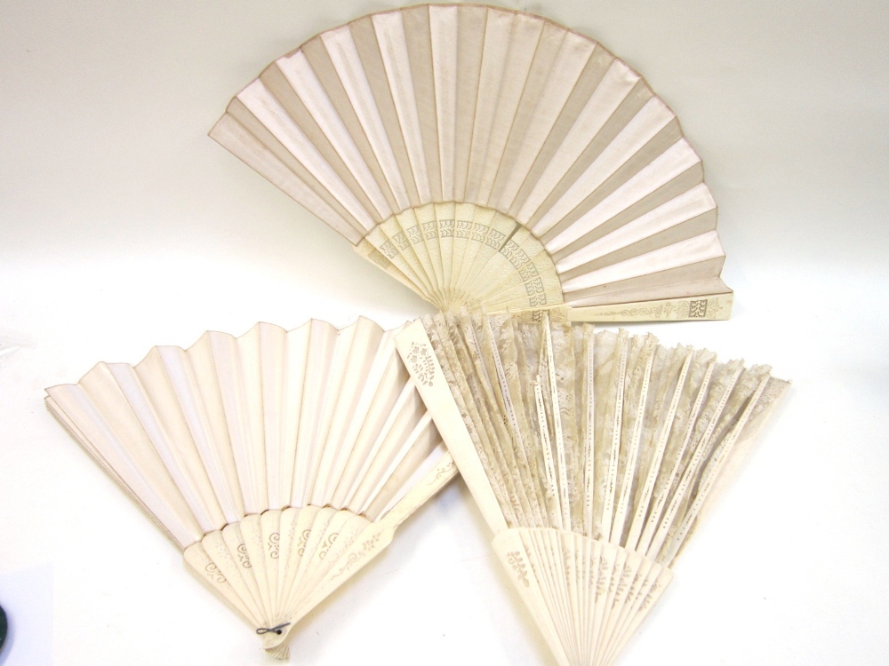 Three various silk or lace bone Fans, the sticks carved with foliage, the largest 50 cms wide (3)