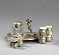 A silver plated ink stand mounted with a figure of a golfer, plus a glass inkpot & pen rest; sold