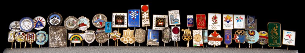 Two sets of pin badges commemorating the summer and winter Olympic Games. the summer set with