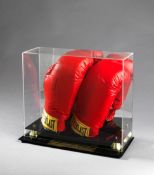 A signed Muhammad Ali boxing gloves presentation, a pair of Everlast boxing gloves, the right hand