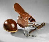 Vintage jockey`s equipment, a brown leather lightweight racing saddle; a cork skull cap; and a