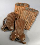 Two pairs of vintage leather football shin pads circa 1910, the larger pair modelled closely along