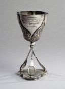 An early example of a table tennis trophy dating to 1902, in the form of a silver plated cup with