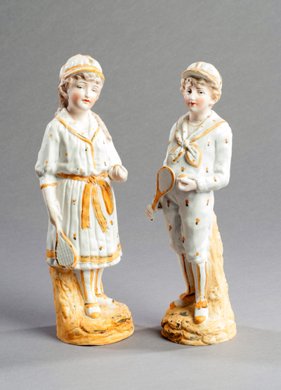 A pair of continental bisque lawn tennis figurines, a young gentleman and a young lady, 24cm., 9 1/