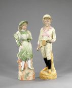 Two 19th century continental bisque figures of tennis players, a boy and a girl both holding a