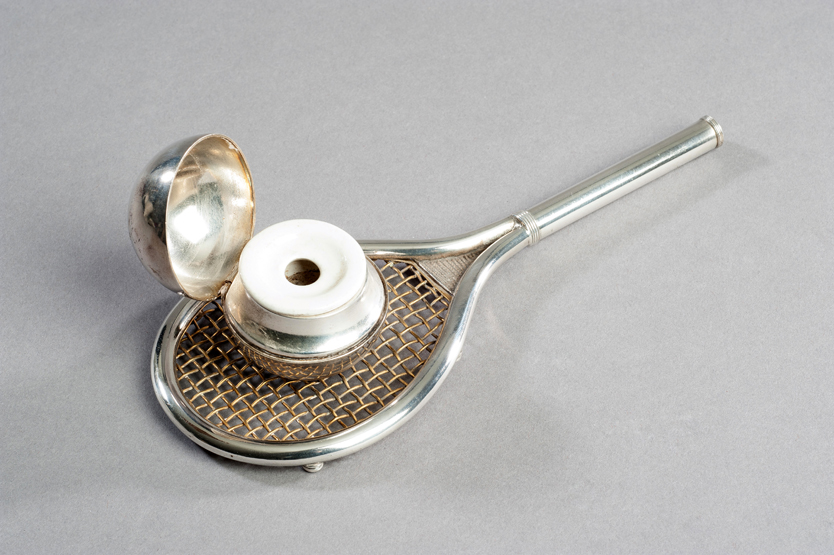 A novelty inkpot designed as a heavy silver-plated tennis racket, circa 1920s, with an unused