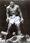 A Muhammad Ali signed b&w photograph of him standing over Sonny Liston, 10 by 8in., signed in blue