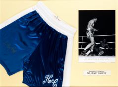 A Sir Henry Cooper signed boxing trunks presentation, the trunks being a navy blue & white replica