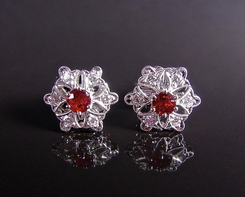 18 ct white gold ruby and diamond flower ear studs. Each stud set with a circular faceted ruby in