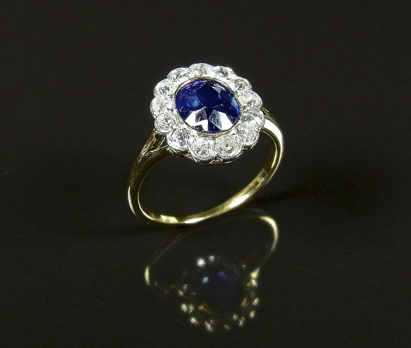 Yellow gold sapphire and diamond ring, tests 18 ct. The oval cut faceted sapphire weighing approx.