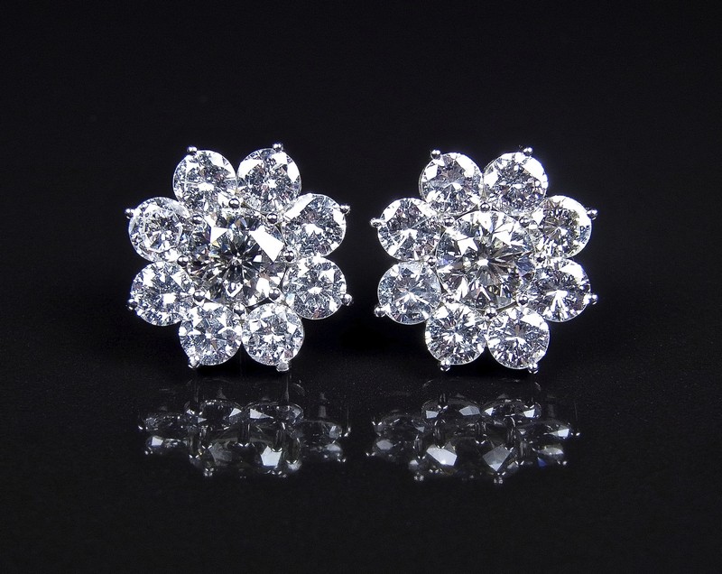 Platinum diamond flower ear studs. Each set with a central round brilliant cut diamond weighing