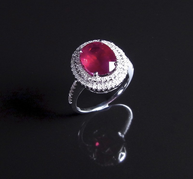 14 ct white gold ruby and diamond ring. The oval cut faceted ruby weighing approx. 3.32 cts to a