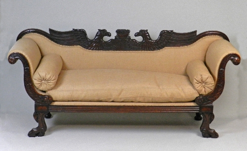 A Regency mahogany Irish scroll end sofa in the Empire style, the double eagle carved back between