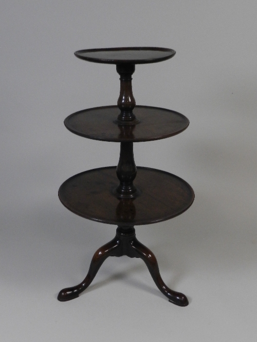A George III mahogany three tier dumb waiter, the circular tray tiers segmented by baluster turned
