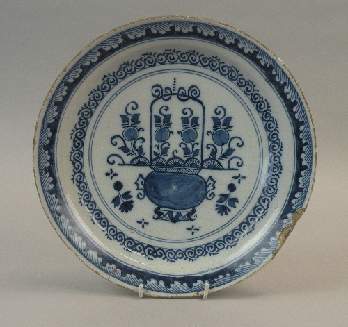 A London delftware blue and white dish, circa 1730, painted with an urn full of flowers within