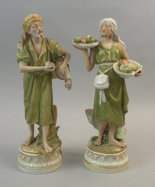 A pair of Royal Dux Arabian figures, a male water carrier holding a water gourd, and a female