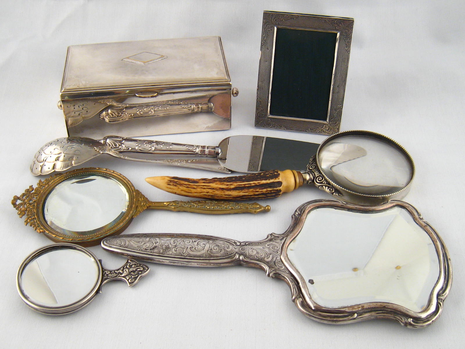 Three hand mirrors, one white metal marked 835, a plated photo frame, two plated serving pieces, a