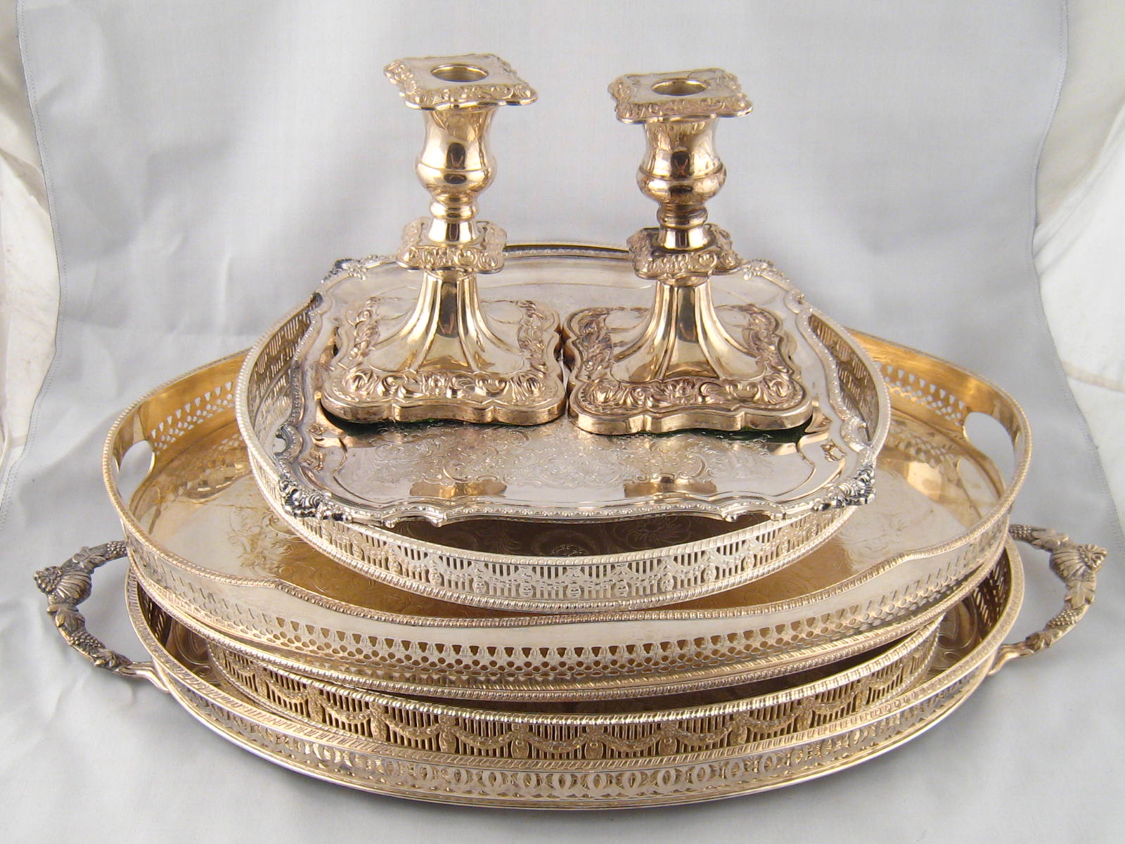 A quantity of silver plated holloware comprising four  galleried trays,  a square waiter and a