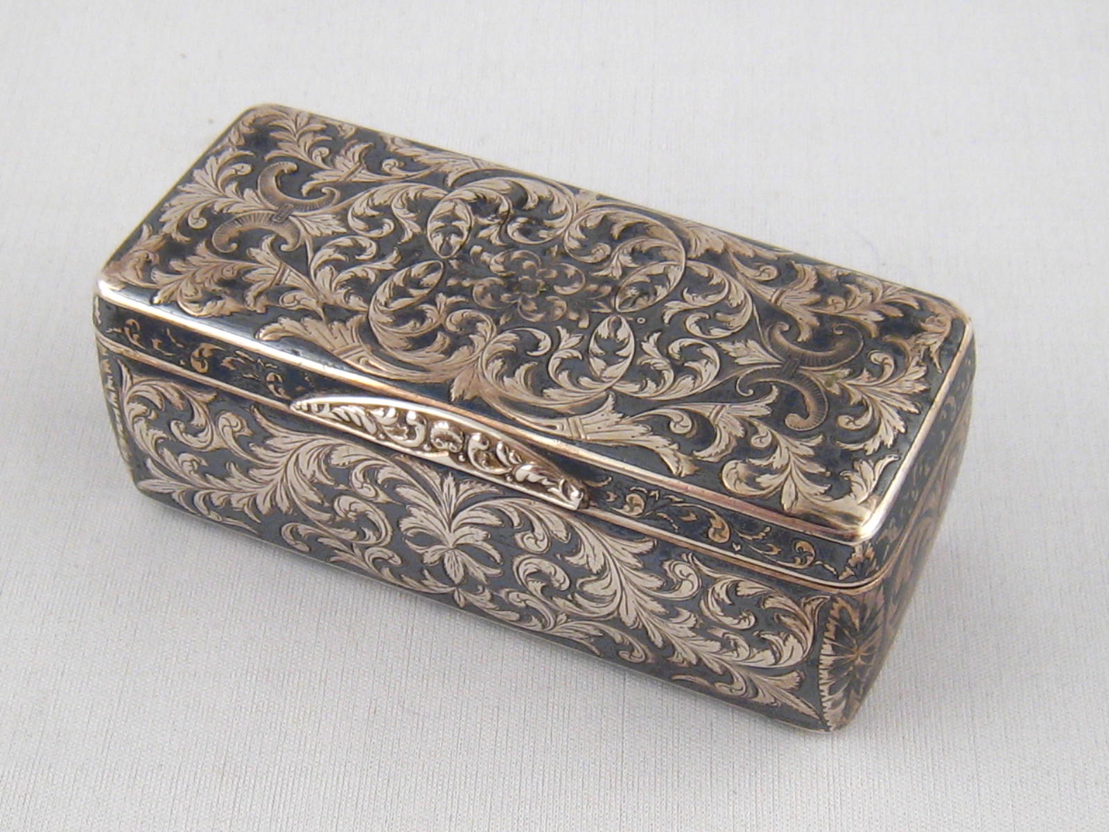 A Russian silver box with engraved scrolling, inset with niello. 9.5x4x3.5cm. Maker A.A., Moscow c.