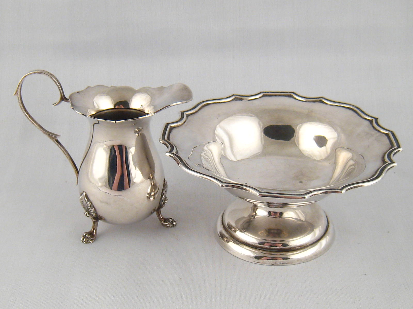 Silver. A Georgian style cream jug on claw feet, Birmingham 1966, and a footed bowl with shaped