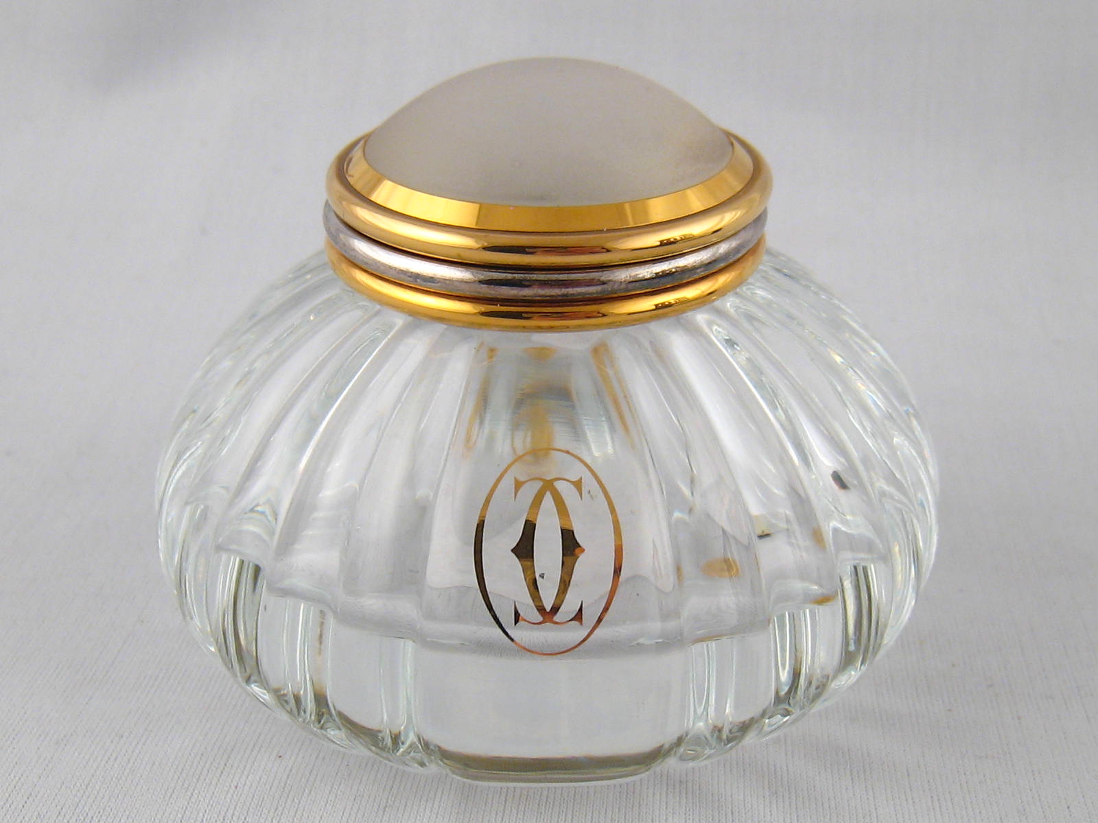 A Must de Cartier inkwell, numbered 017909, 1989, with ribbed glass body and gilt mount.