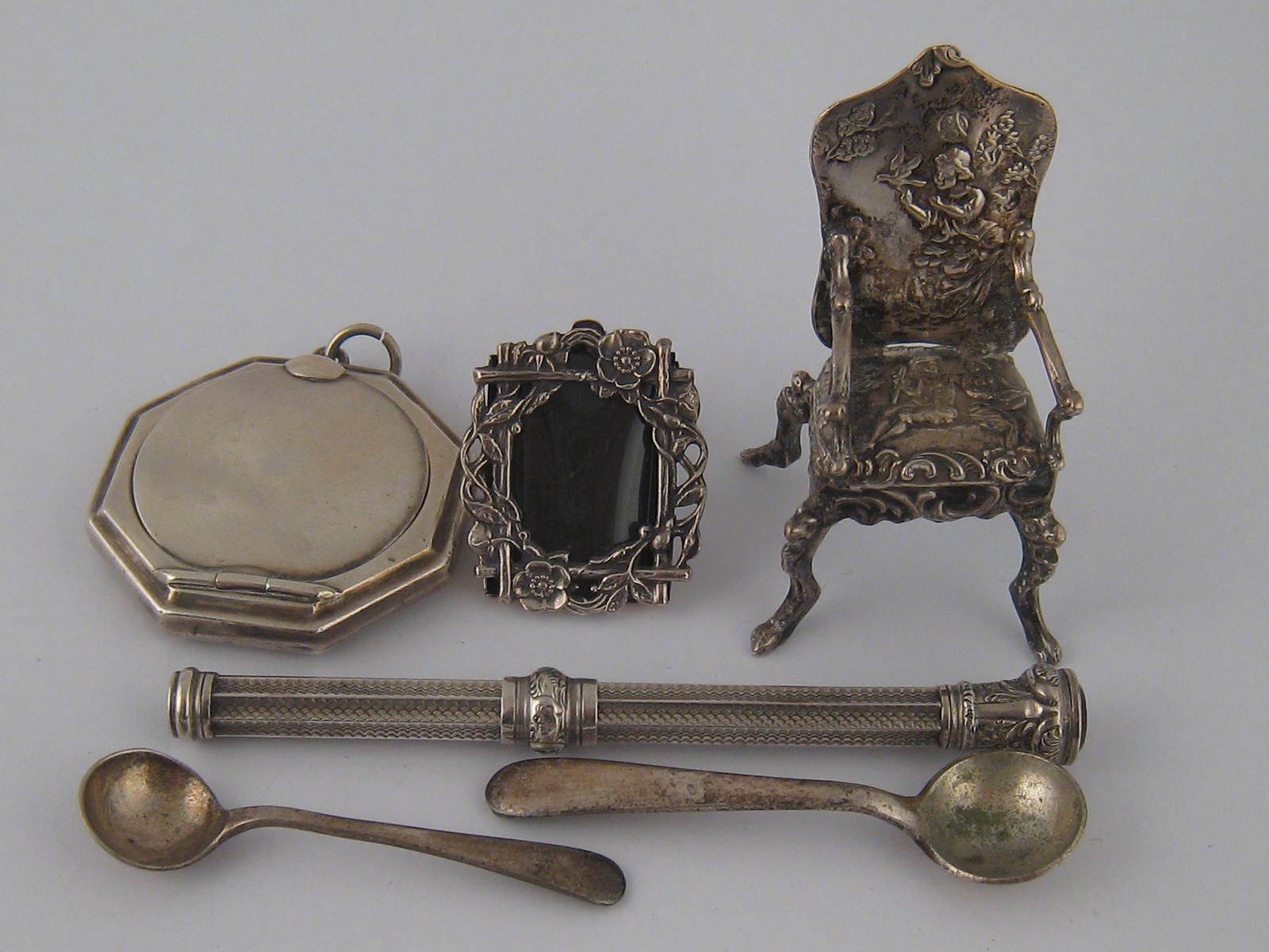 A silver octagonal pendant compact, Birmingham 1924, a miniature strut back frame marked sterling, a