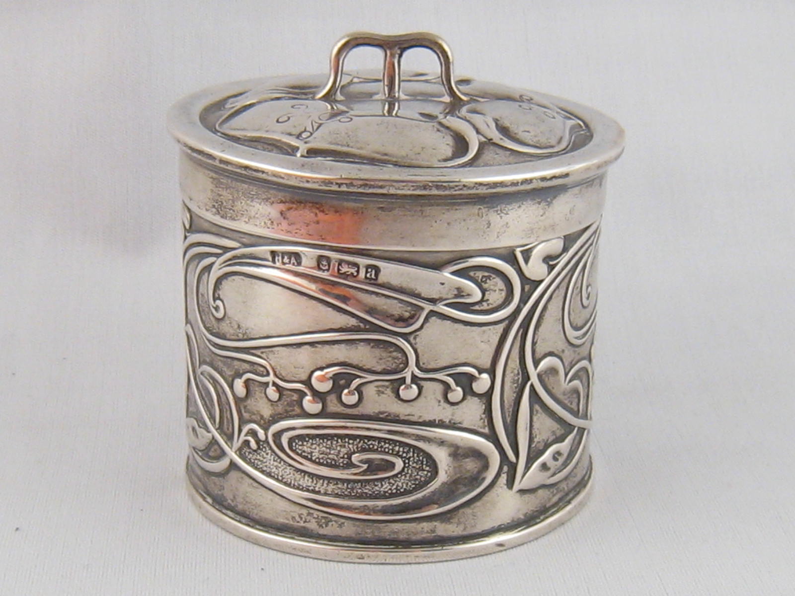 A late Victorian silver Art Nouveau lidded box, the body  with entwined foliage, heart shaped motifs