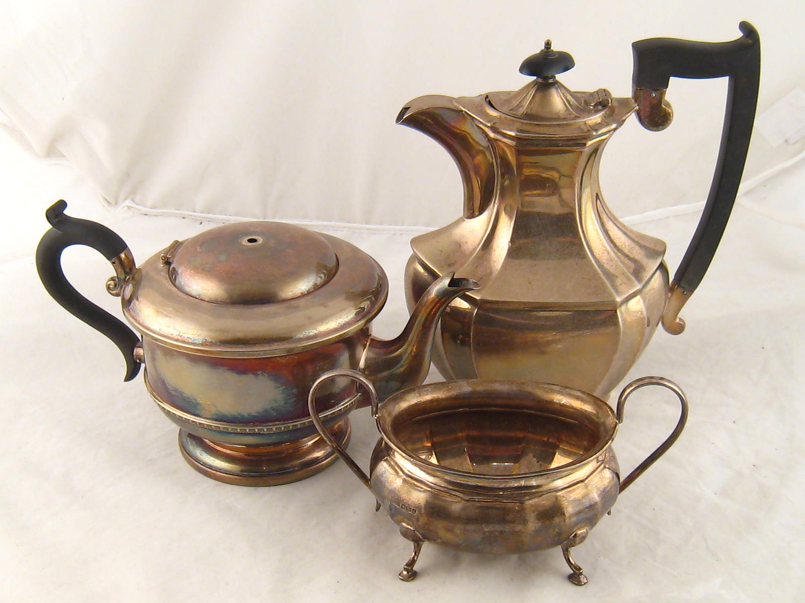 Silver. A teapot, Birmingham 1932, finial missing, a hot water jug, London 1934, and a sugar bowl,