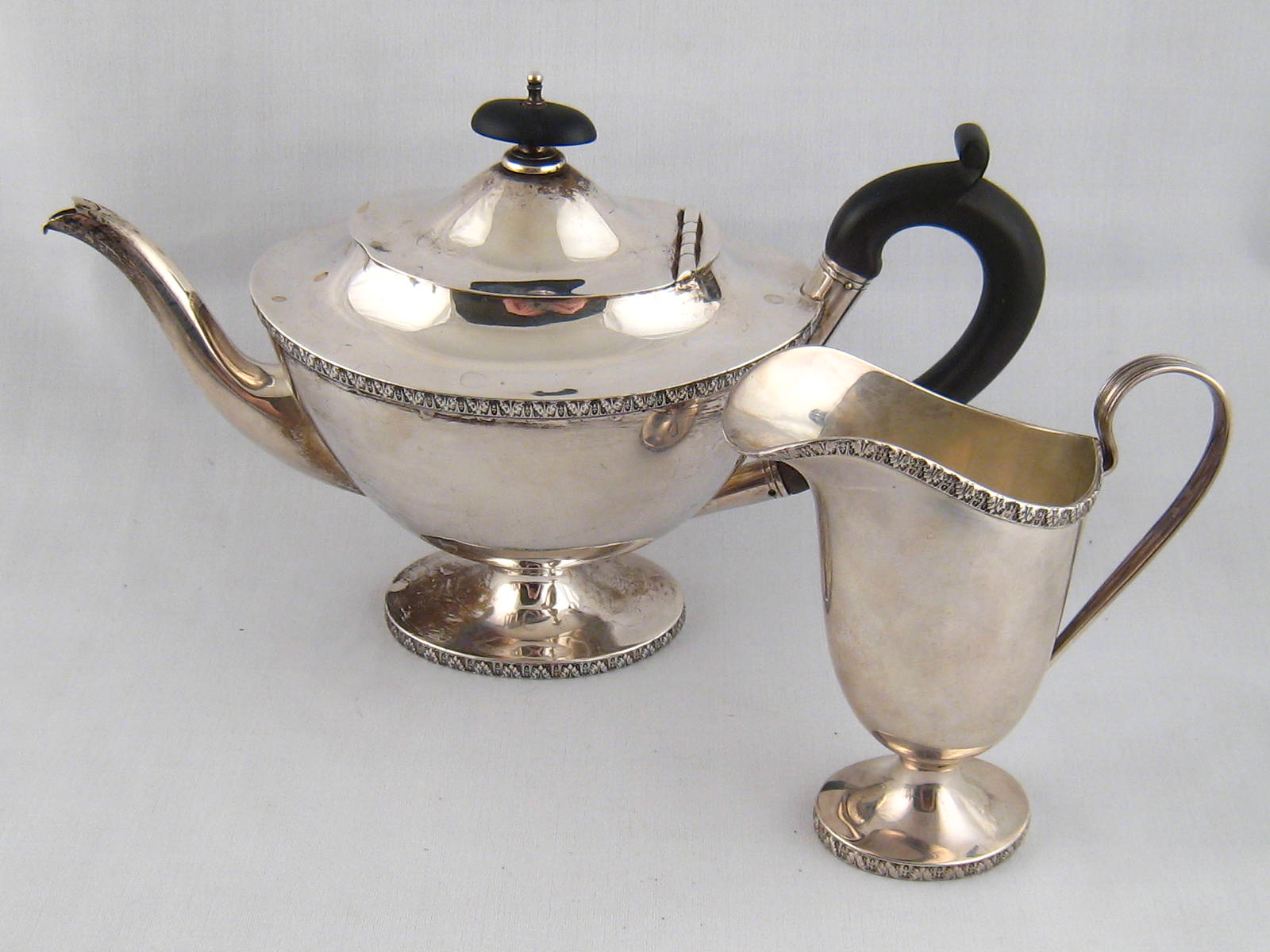 A silver teapot and helmet cream jug in the Adam manner by T.Latham & E. Morton, Birmingham. 1916.