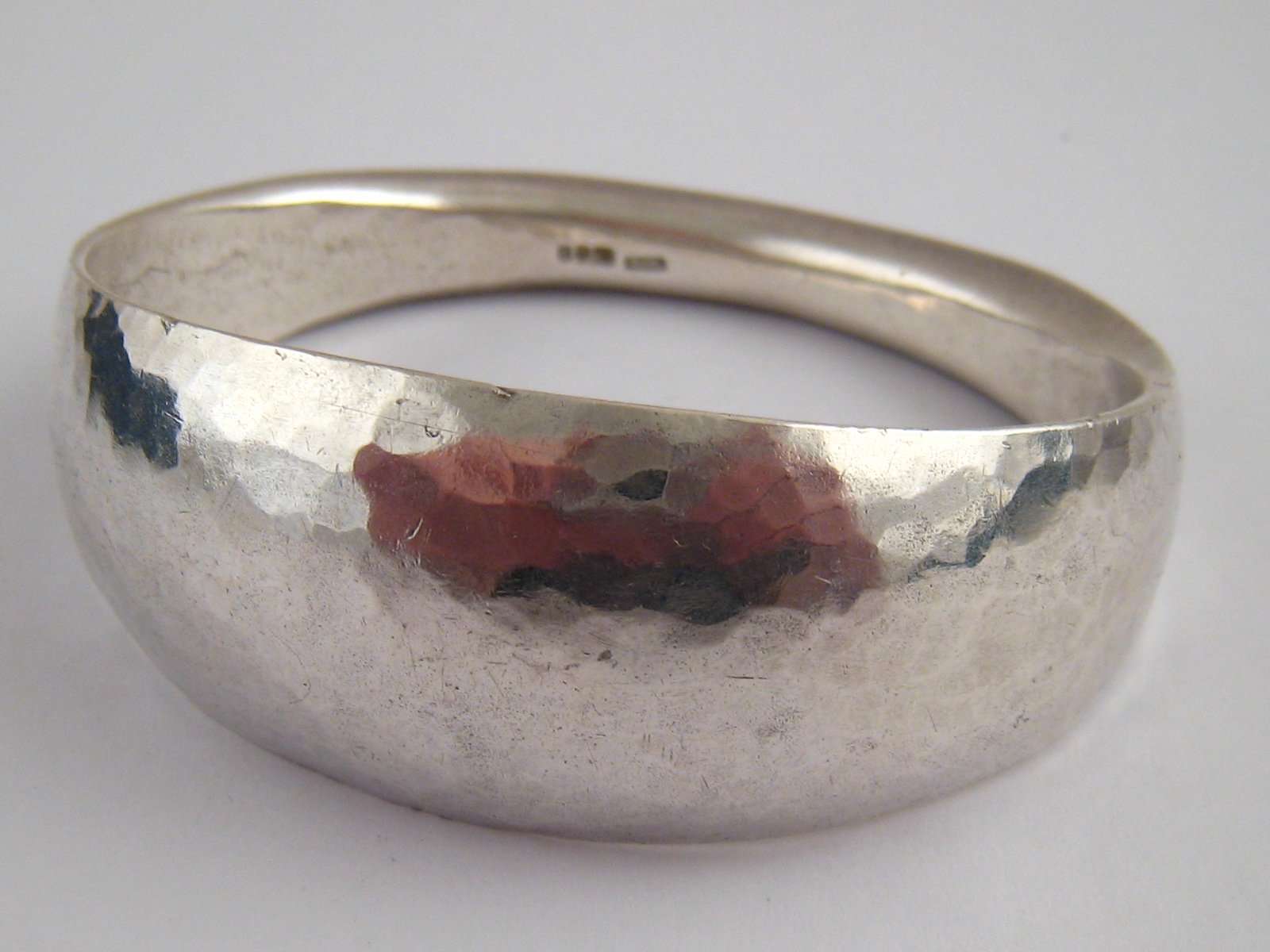 A heavy silver bangle with hammered finish, approx. 3cm at widest point, 95 grams.