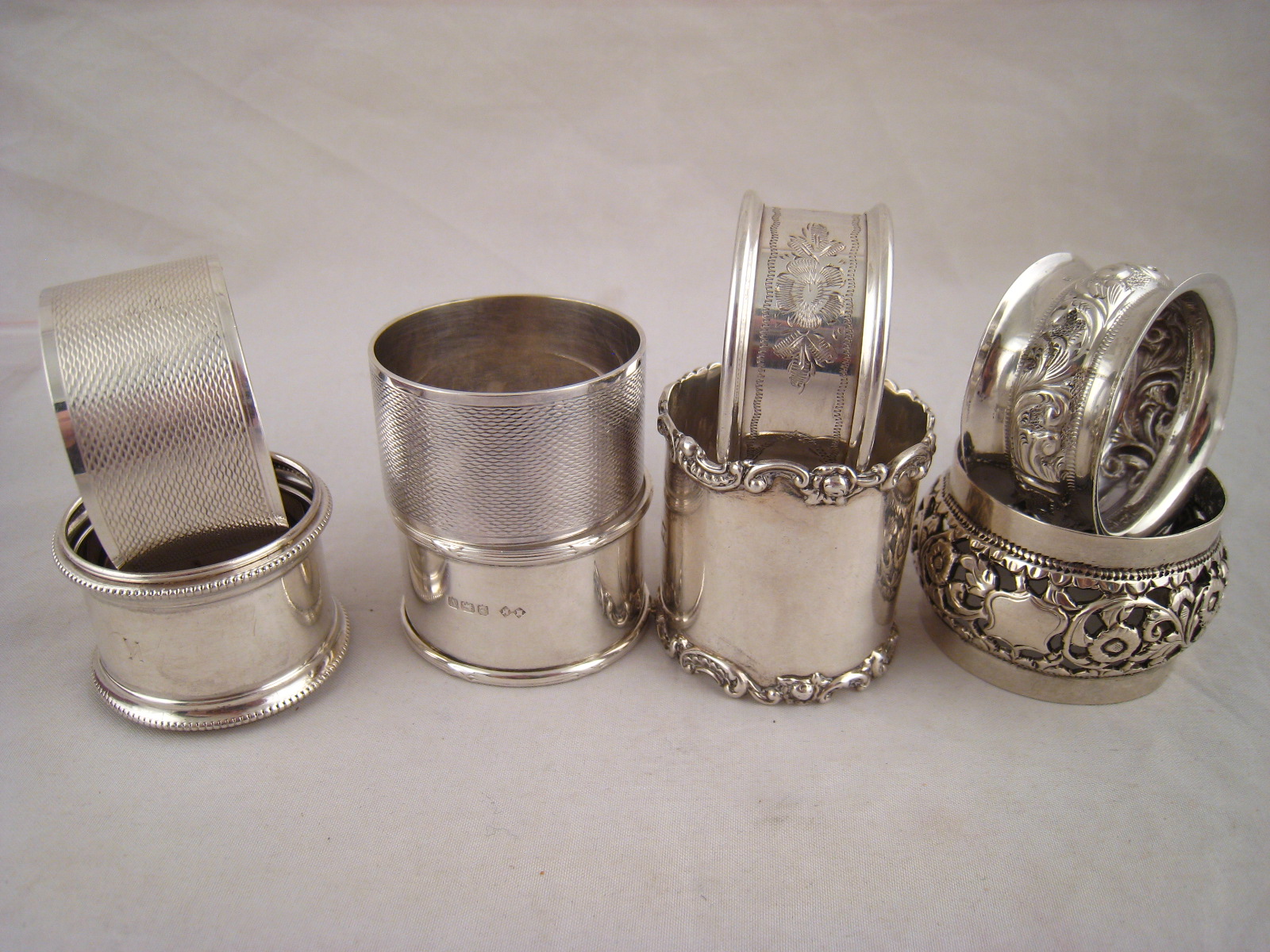 Four silver and four white metal ( all test silver) napkin rings. Wt. 195g