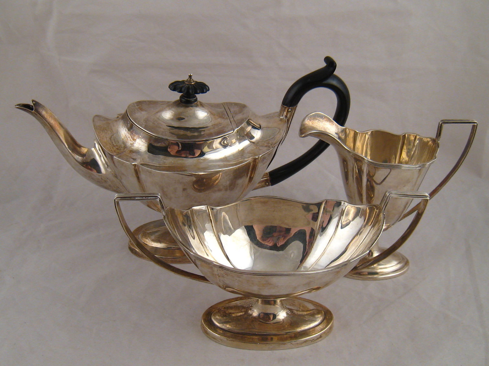 A three piece silver matched teaset of footed panelled oval shape, teapot and jug, Birmingham