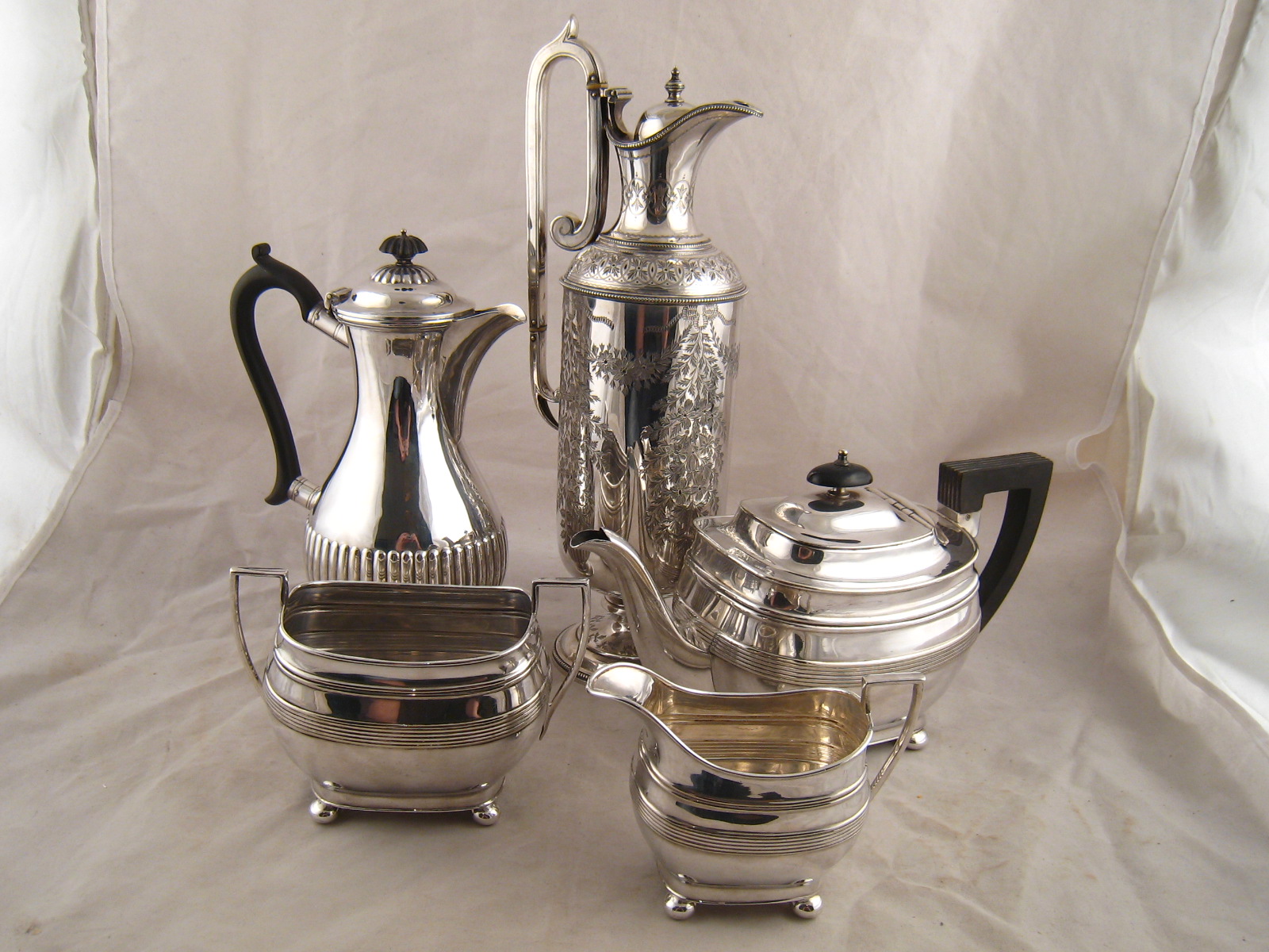 Silver plate. A three piece teaset of barge shape on ball feet, a half reeded coffee pot and a