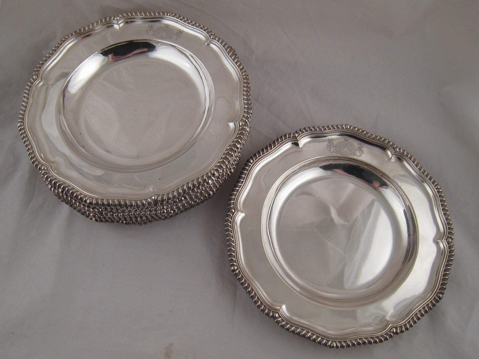 A set of twelve Elkington & Co. silver plated second course plates in the Georgian style with lobed