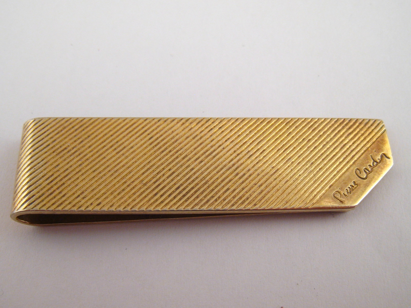 A gilt metal (tests silver) money clip, signed Pierre Cardin, approx. 5.5cm, 17.4 grams.