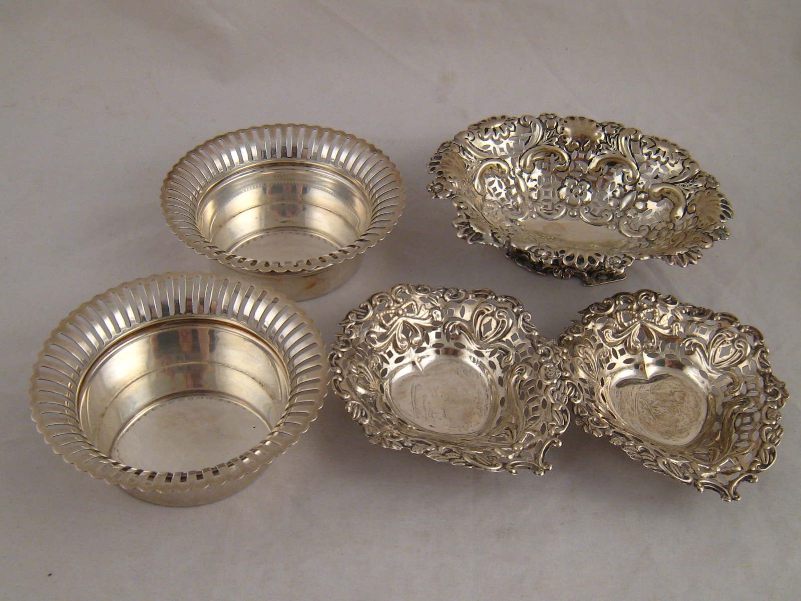 Silver. A pair of coasters with pierced rims, Birmingham 1910, a pair of pierced heart shaped
