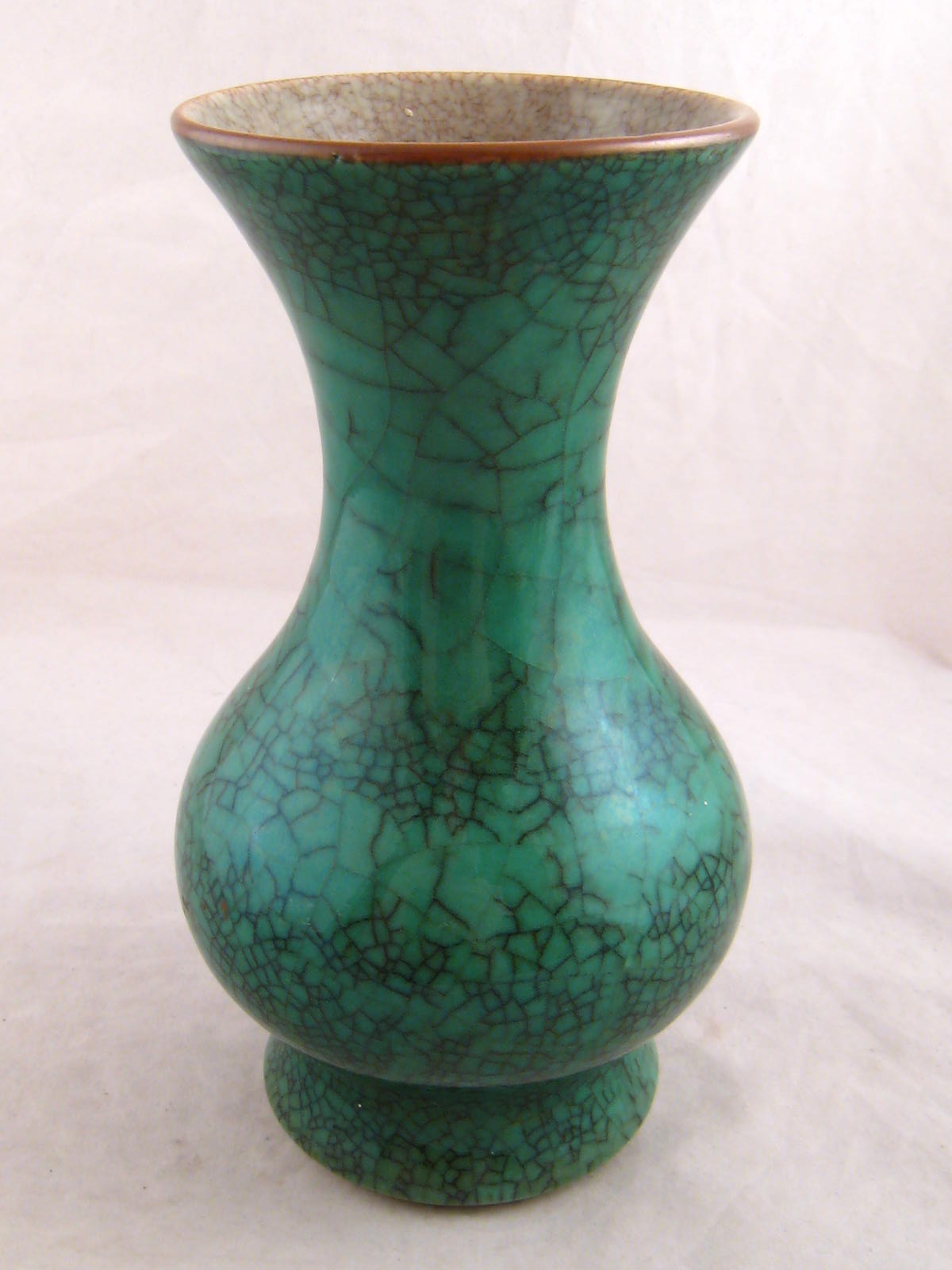 A Chinese green raku glazed ceramic baluster vase with everted rim and raised foot , the interior
