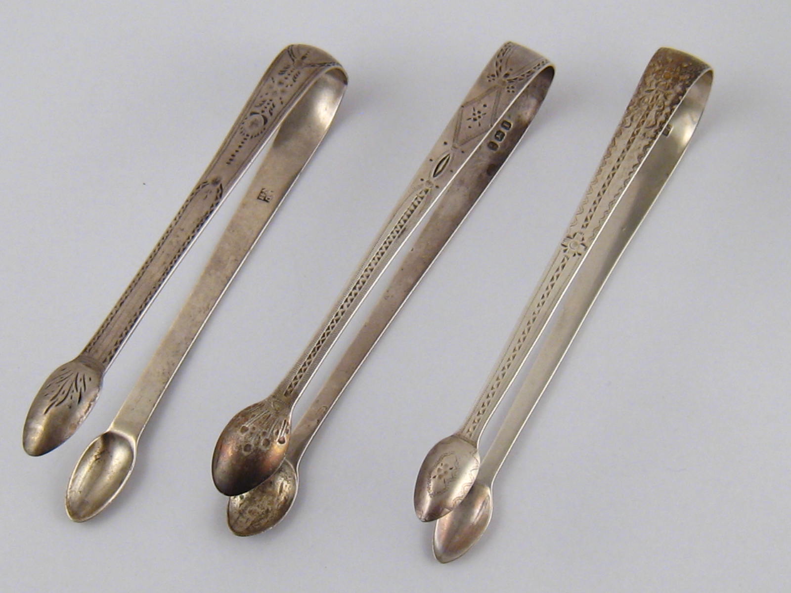 Three pairs of Georgian brightcut silver sugar tongs, John Lambe, 1795, George Smith & Thomas