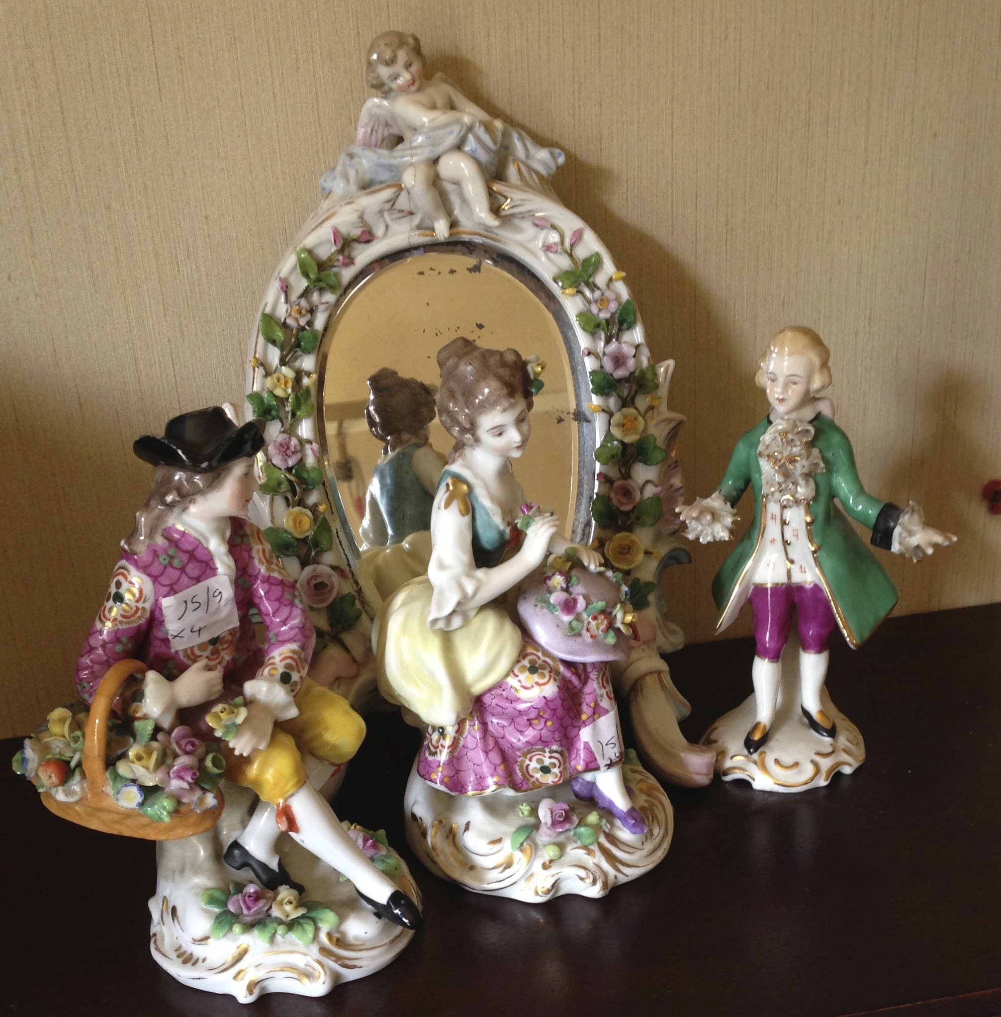 Three continental figures and a porcelain mirror