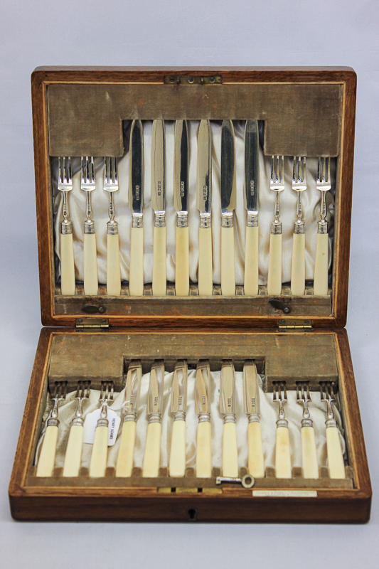 A set of twelve silver dessert knives and twelve forks, maker Pearce & Sons Limited, 1919 with white