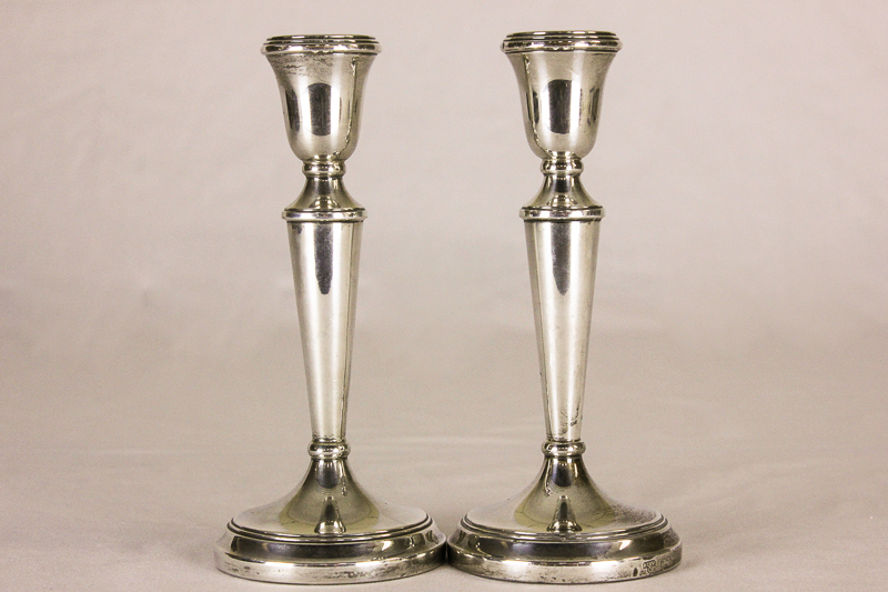 A pair of silver candlesticks with tapered columns and sloping bases, Birmingham 1978, 19cm high (