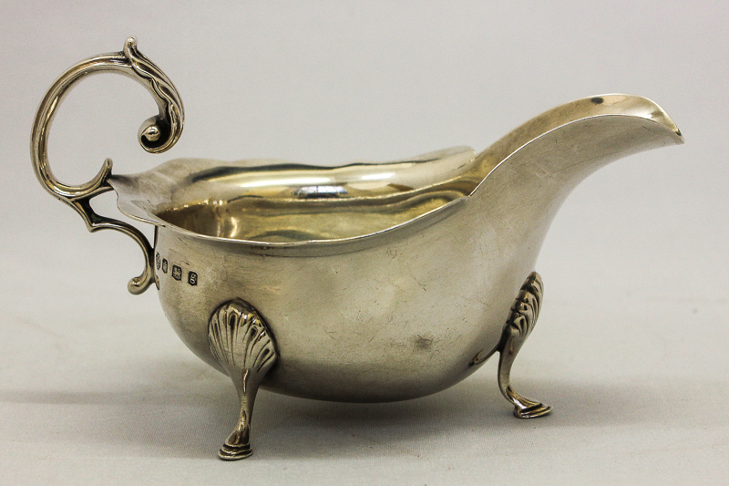 A silver sauce boat, maker William Hutton & Sons Ltd, Sheffield 1924 with waved border and scroll