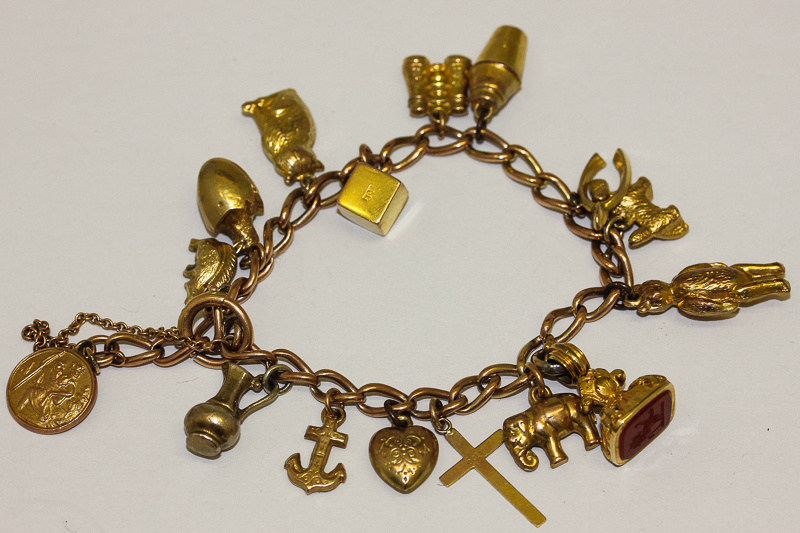 A 9ct gold chain link charm bracelet with sixteen various gold and gilt charms, 30gms gross