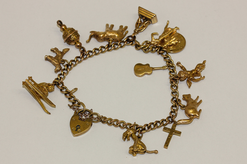 A 9ct gold charm bracelet, curb link with padlock clasp hung with various charms, 39.2gms gross