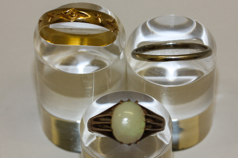 A platinum wedding band, 2.9gms; an 18ct gold wedding band, 2.5gms and an opal single stone ring