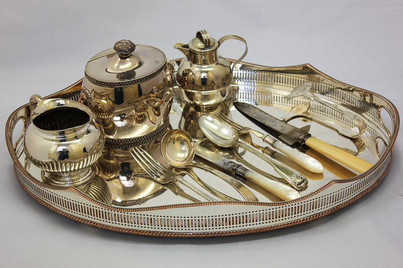 A plated gallery tray; a plated tea caddy; a sugar bowl and cream jug and six white handled