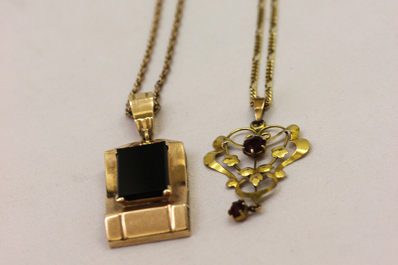 A 9ct gold and garnet Art Nouveau pendant and a 9ct gold and black onyx pendant